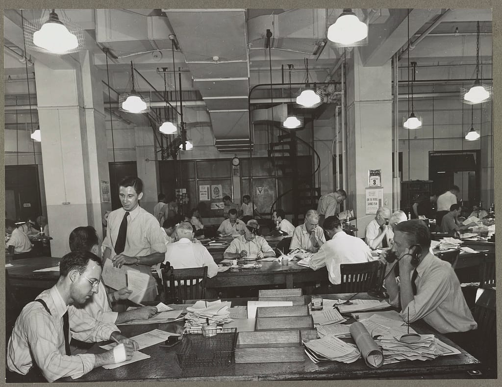 News room of the New York Times newspaper Right foreground, city editor. Two assistants, left foreground. City copy desk in middle ground, with foreign desk, to right; telegraph desk to left. Make-up desk in center back with spiral staircase leading to composing room. Copy readers go up there to check proofs.